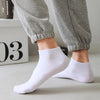 A close-up shot of a person's legs and feet wearing white thin ankle socks.