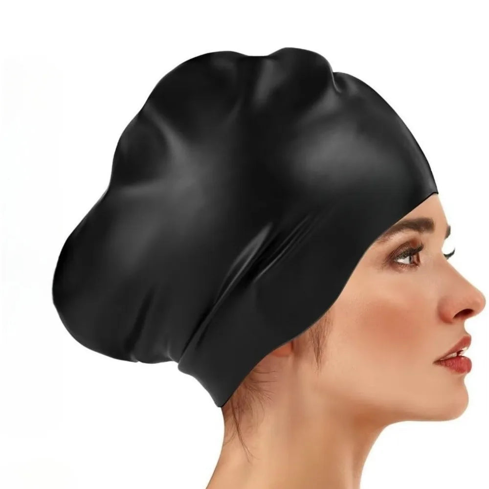 A black silicone swim cap is shown on a person's head, highlighting its smooth texture and fit.