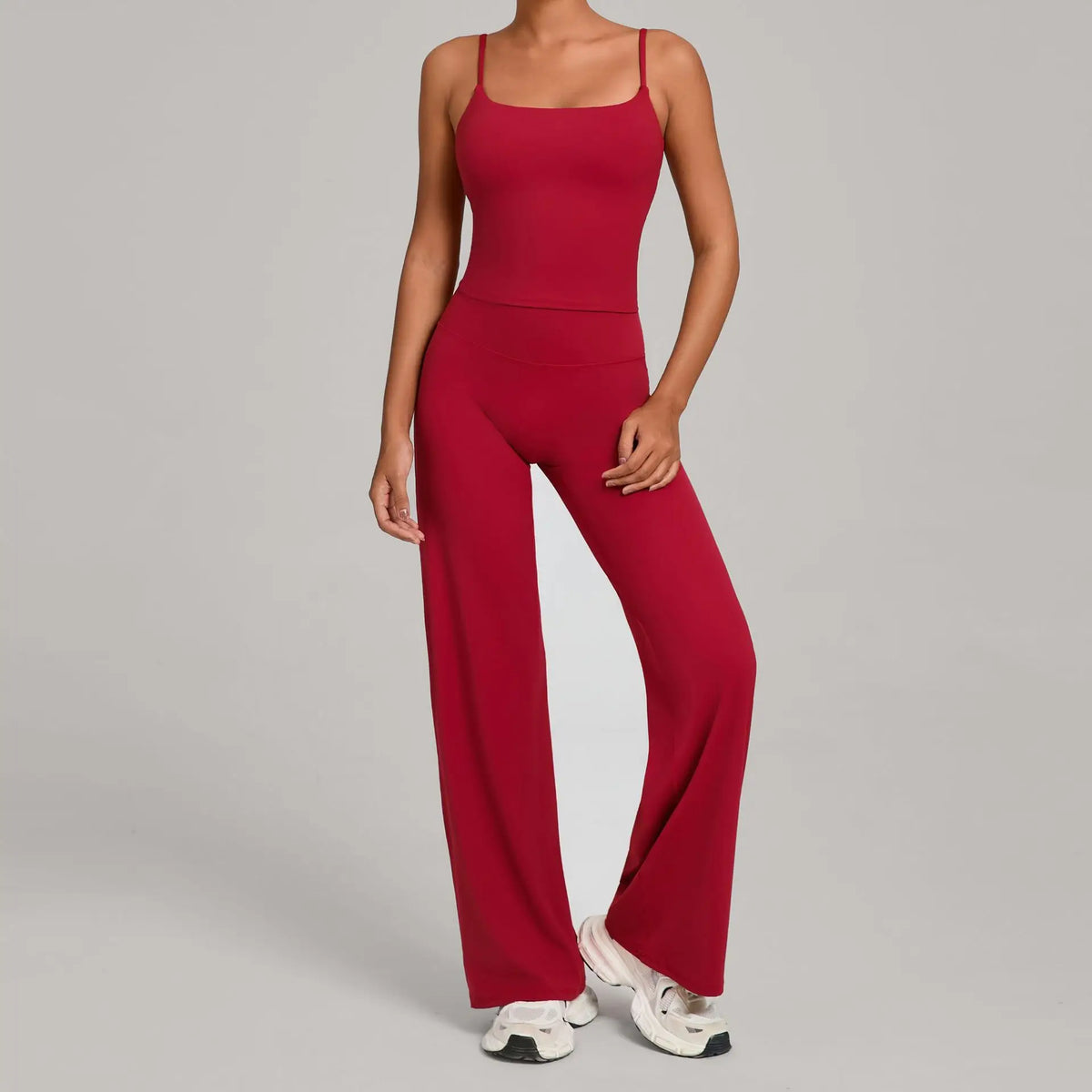 A woman wearing a long-sleeved, high-waist red yoga and fitness tracksuit set.
