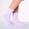 Purple yoga socks worn on a foot, showing the texture and fit.