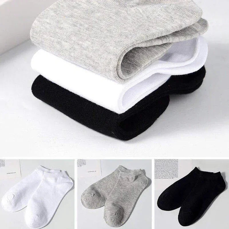 Una pila de calcetines unisex de algodón transpirable en gris, blanco y negro.
