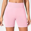 Un modèle porte des short de yoga sans couture, taille haute, rose clair, pour la salle de sport et la fitness.