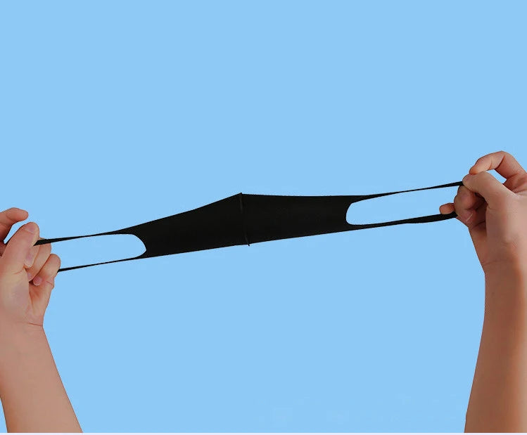 Hands holding a black UV protection face mask for summer and travel
