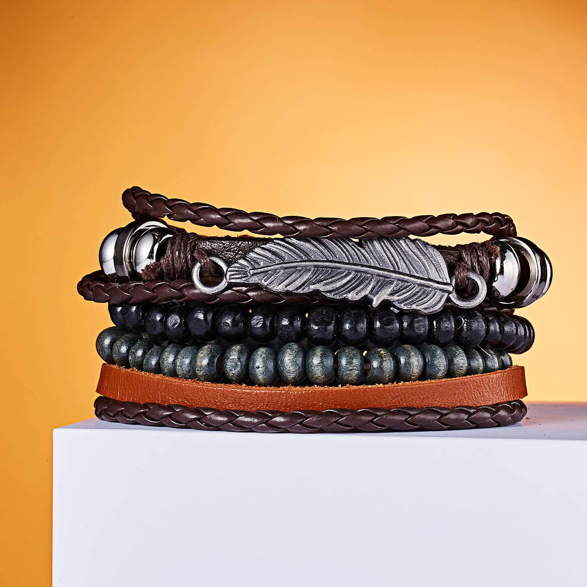 Stapel von handgemachten Lederblatträfelchen-Armbändern in verschiedenen dunkelbraunen und schwarzen Leder- sowie silbernen P