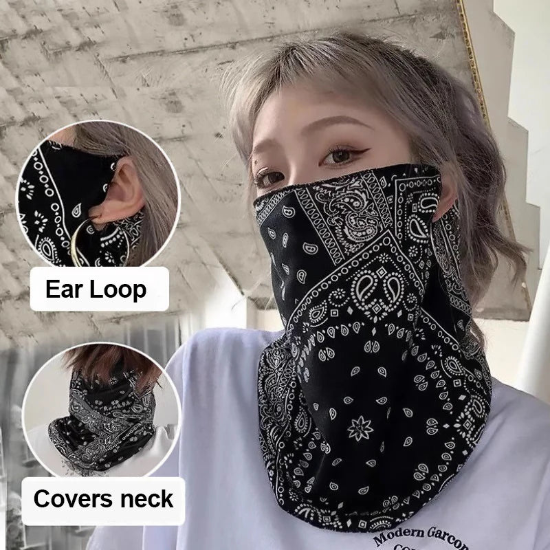 Primer plano de una mujer usando un pañuelo protector UV con estampado paisley negro cubriendo su cara y cuello.