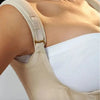 A close-up of a beige adjustable body shaper corset vest top worn on a model's upper torso.