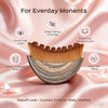 A wooden lymphatic contour face brush with a stone storage case shown against pink fabric.