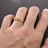 A close-up of a hand wearing a gold-toned stainless steel ring with a moon and star design.