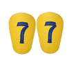 A pair of yellow mini football shin guards with the number 7 printed in blue on each.