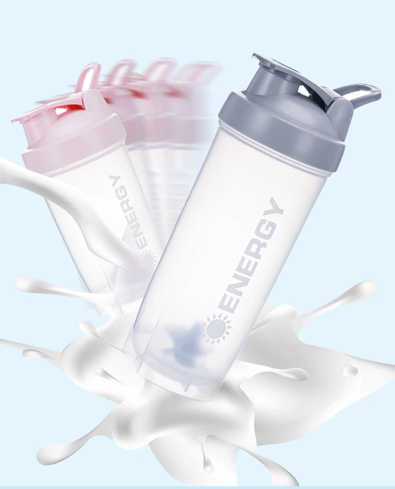 Durchsichtbare, tragbare Protein-Shakerflasche mit silbernem Deckel, umgeben von weißen Flüssigkeitsspritzern.