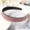 Pinkes Kristall-Strass-Haarband auf weißem Untergrund mit unscharfem Hintergrund.