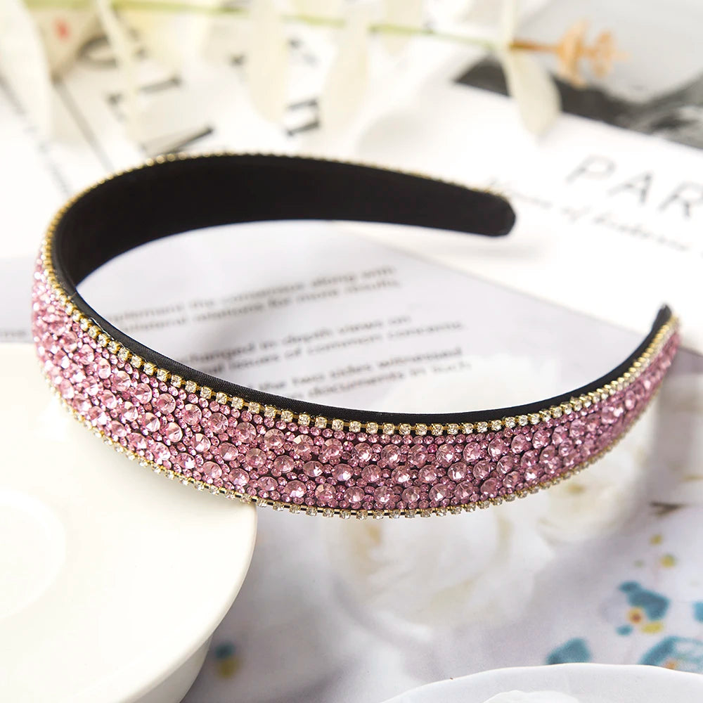 Pinkes Kristall-Strass-Haarband auf weißem Untergrund mit unscharfem Hintergrund.