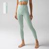 Un modèle porte des leggings de performance taille haute vert menthe clair et un crop top assorti.
