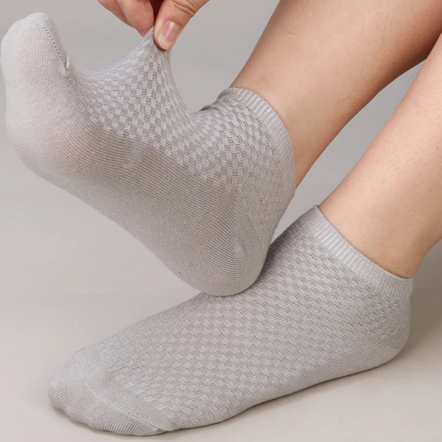 A close-up of a person's foot wearing light gray bamboo fibre anti-odor socks.