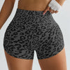 A woman wearing leopard print high-waist seamless shorts and a white crop top.