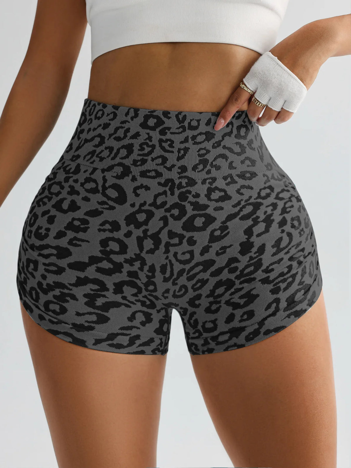 A woman wearing leopard print high-waist seamless shorts and a white crop top.