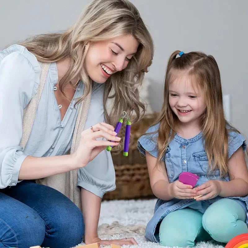 A young woman is playing with a carrot fidget stress relief toy with a young girl.