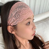 Primer plano de una mujer usando una diadema de encaje floral rosa transparente en la frente, con cabello largo y oscuro.