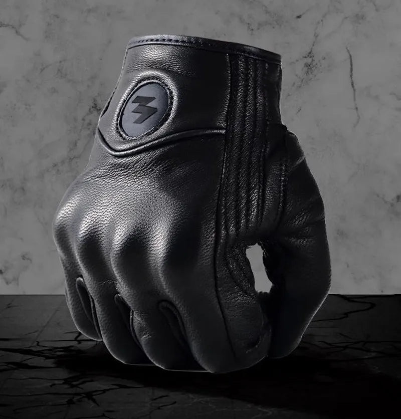 A close-up of black full finger leather motorcycle riding gloves with a silver lightning bolt emblem.