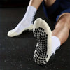 A close-up of a pair of non-slip silicone sports socks with a black grid pattern on a white background.