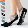 A pair of black silicone anti-slip pilates and yoga socks shown on a person's foot.