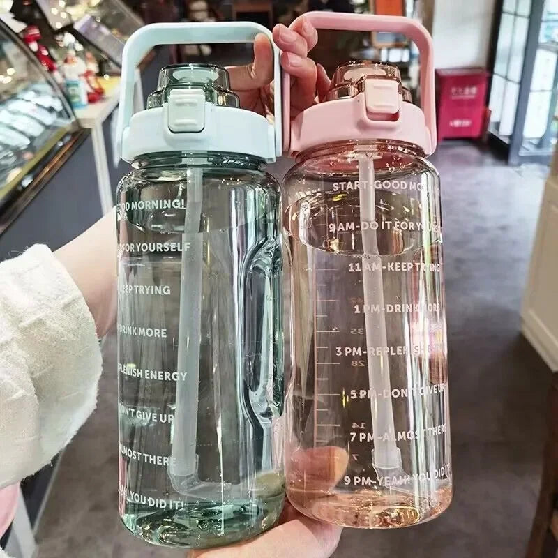 Deux grandes bouteilles d'eau de sport avec marqueurs de temps, une transparente et une rose.
