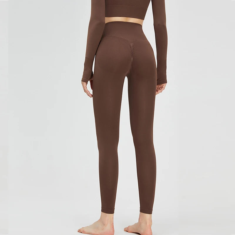 A model is wearing high-waist seamless yoga leggings in a brown color.