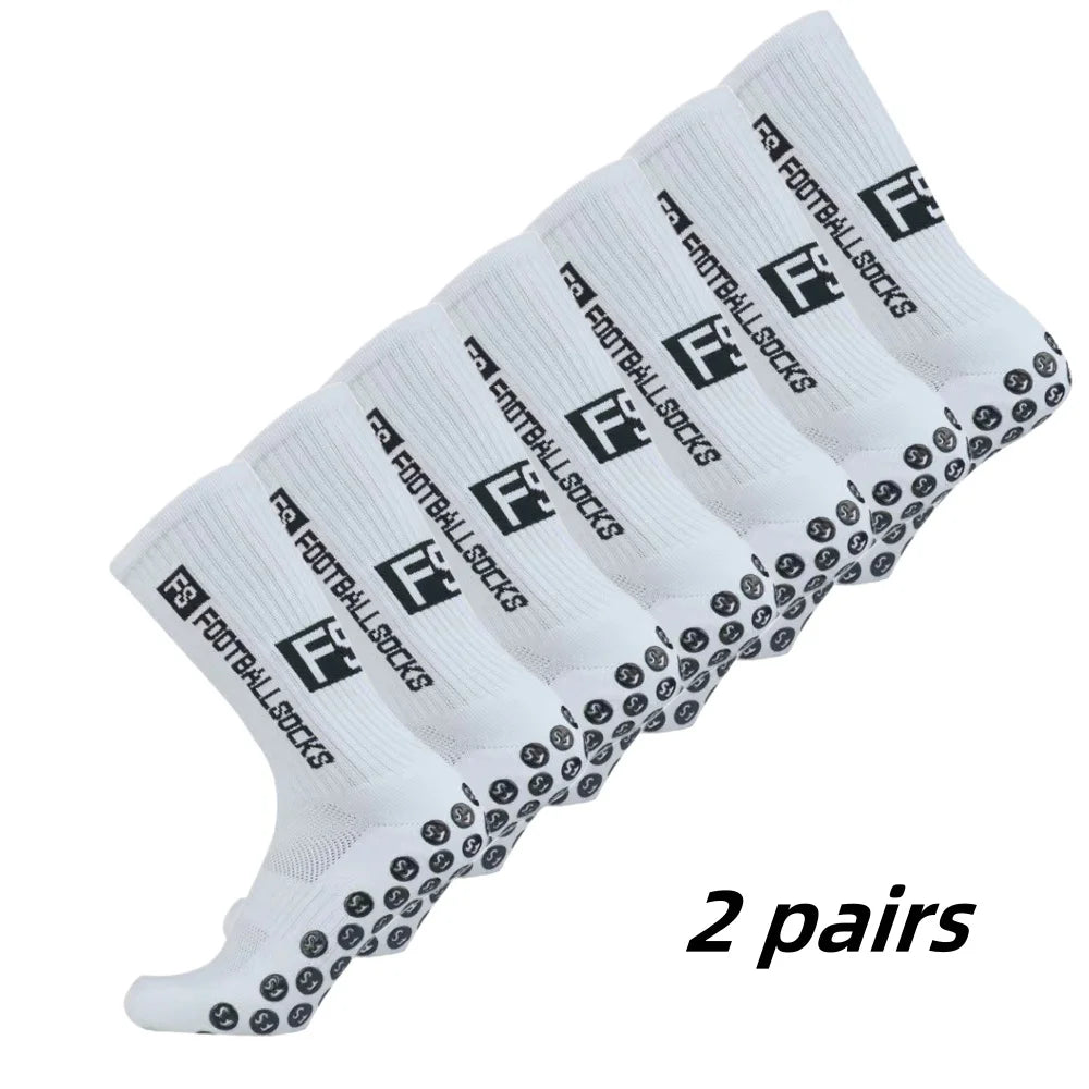 Two pairs of white non-slip grip football socks with black text and logos