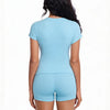A woman wearing a light blue performance workout set consisting of a short-sleeved top and matching shorts.