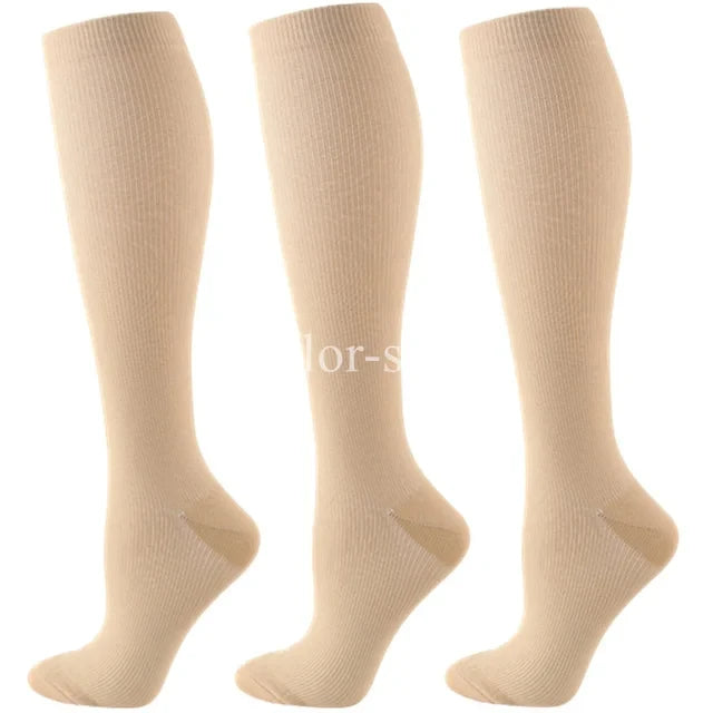 Three pairs of beige compression socks shown from the side.
