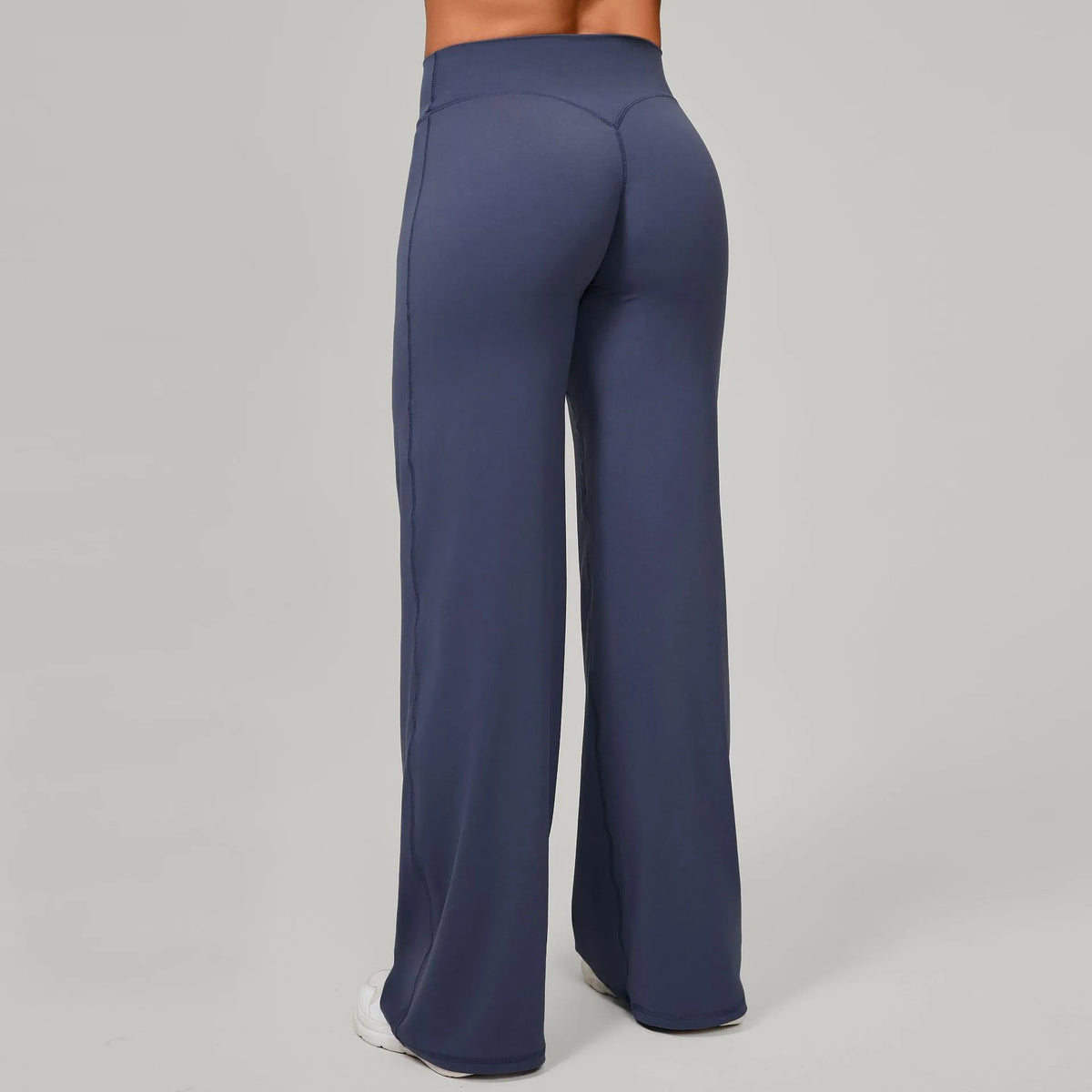 A full-length image of dark blue high waisted yoga pants for women shown from the rear.