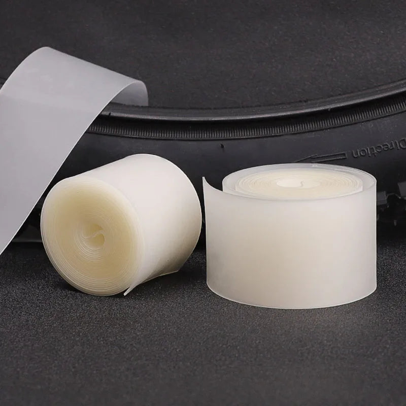 Rolls of bicycle puncture protection liner placed on a dark surface.