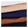 A stack of compression socks in various earth tones and dark blues, showing different shades of brown, beige, navy, and black