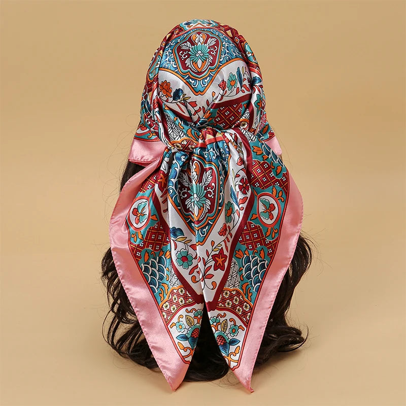 Elegant satin square scarf featuring intricate floral patterns in pink, blue, and white for hijab and hair