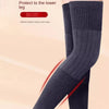 A close-up of dark gray wool knee warmers being worn on a leg.
