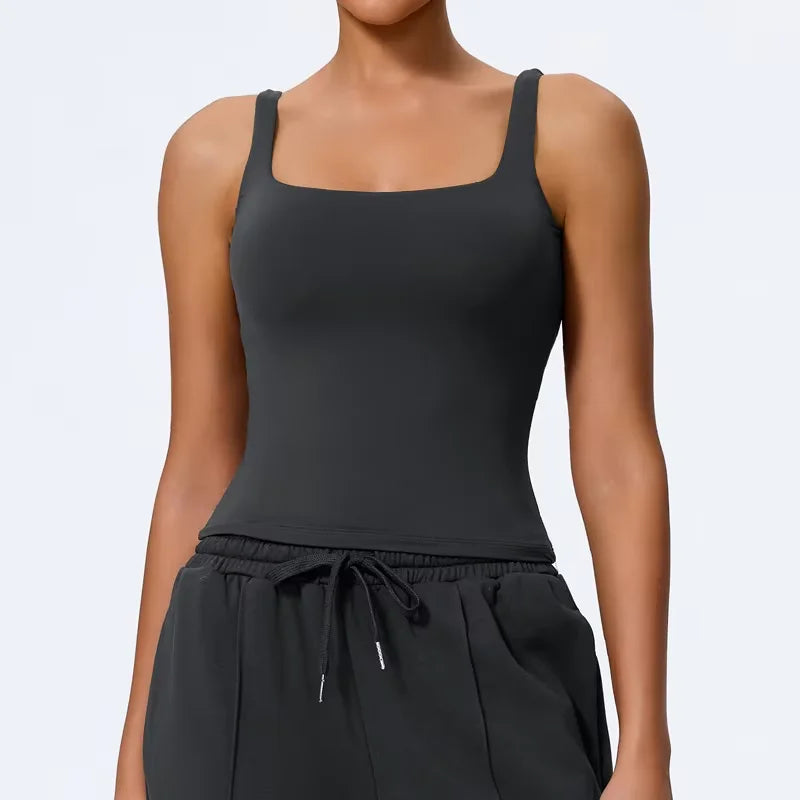 Modelo vistiendo un top y pantalones de yoga negros de cuello cuadrado.