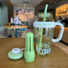 A clear glass water bottle with a handle and straw, labeled ICE CREAM, sits on a wooden table next to a lime green silicone b
