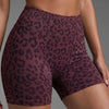Un mannequin porte des shorts de yoga à taille haute à imprimé léopard violet foncé.