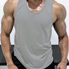 A muscular man wearing a gray sleeveless tank top and black shorts.