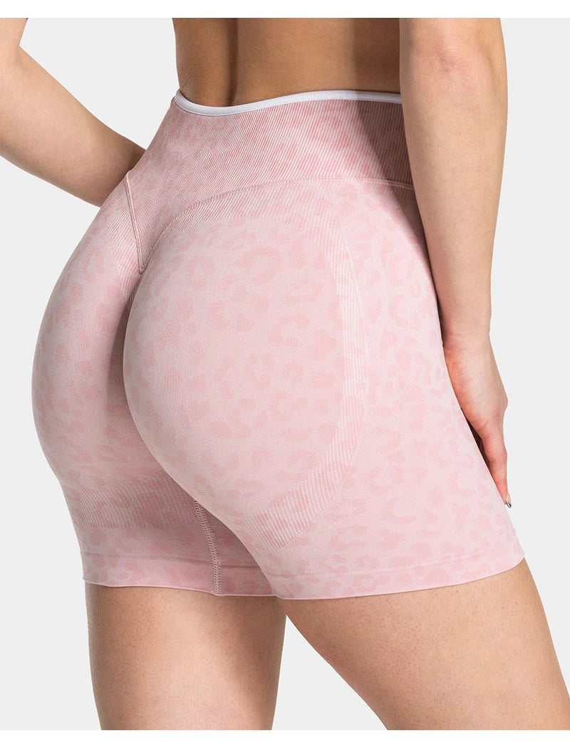 Light pink leopard print seamless yoga shorts worn by a person.