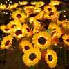 A close-up of bright yellow solar sunflower LED lights blooming on a plant.