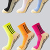 A collection of performance sports grip socks in yellow, orange, and pink colors shown from the side.