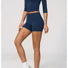 A woman models a navy blue yoga and fitness leggings set, featuring long-sleeved tops and high-waisted bottoms.