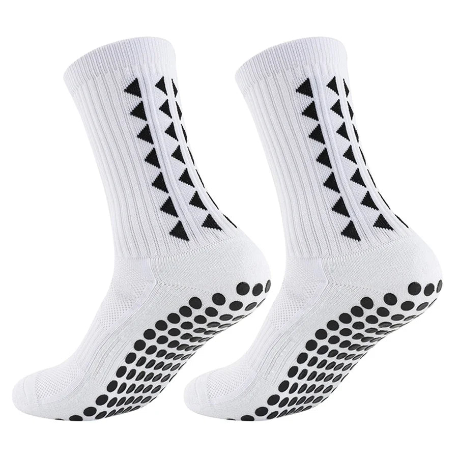 A pair of white non-slip athletic grip socks featuring black chevron and dot patterns.