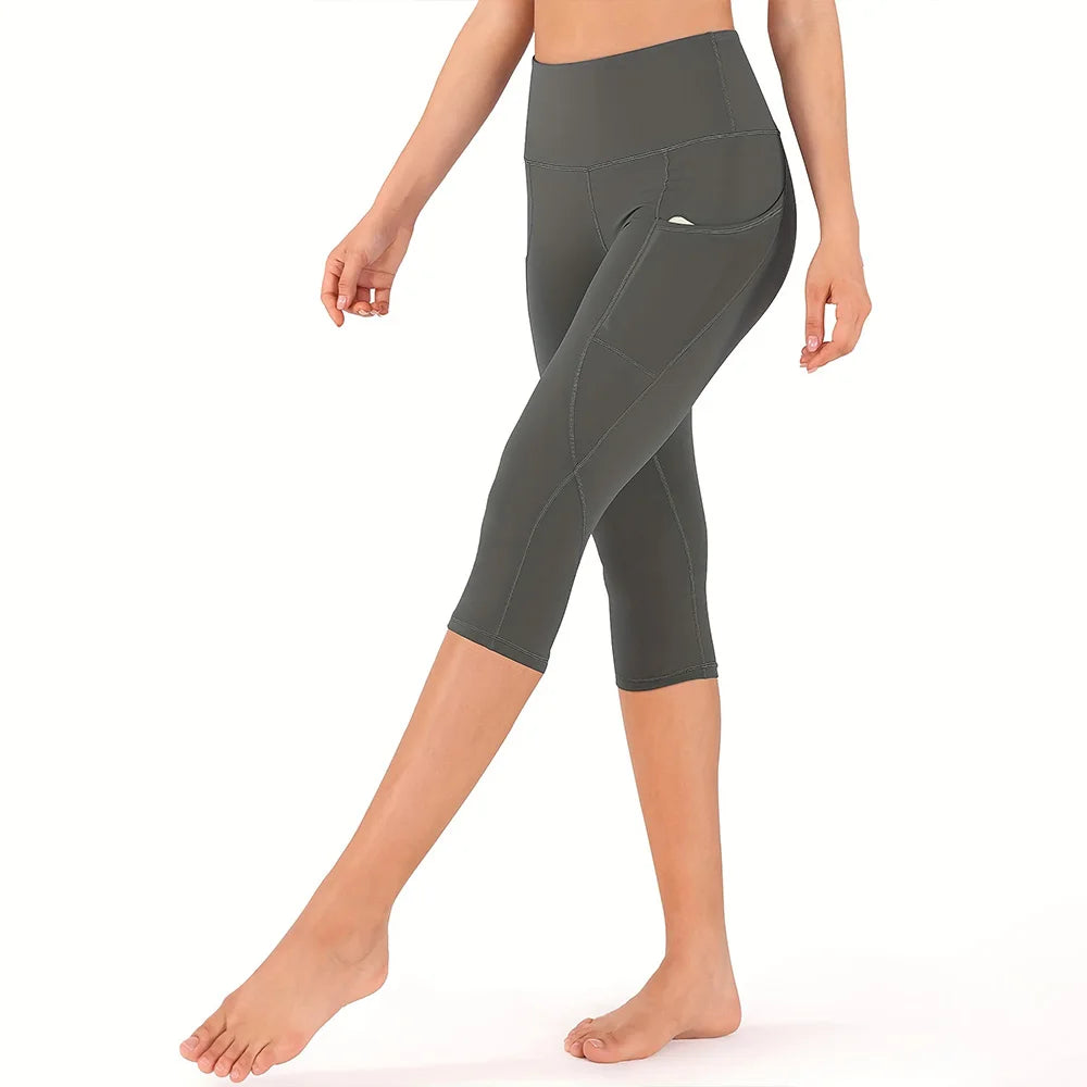 Una mujer vistiendo leggings deportivos grises de cintura alta con bolsillos de costura.