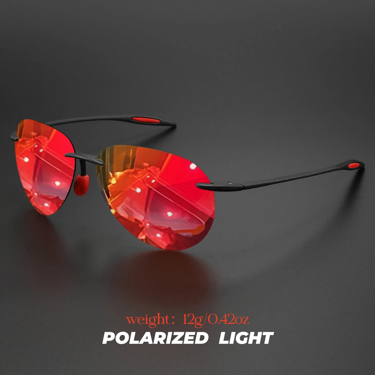 A pair of red polarized light aviator sunglasses resting on a dark surface.