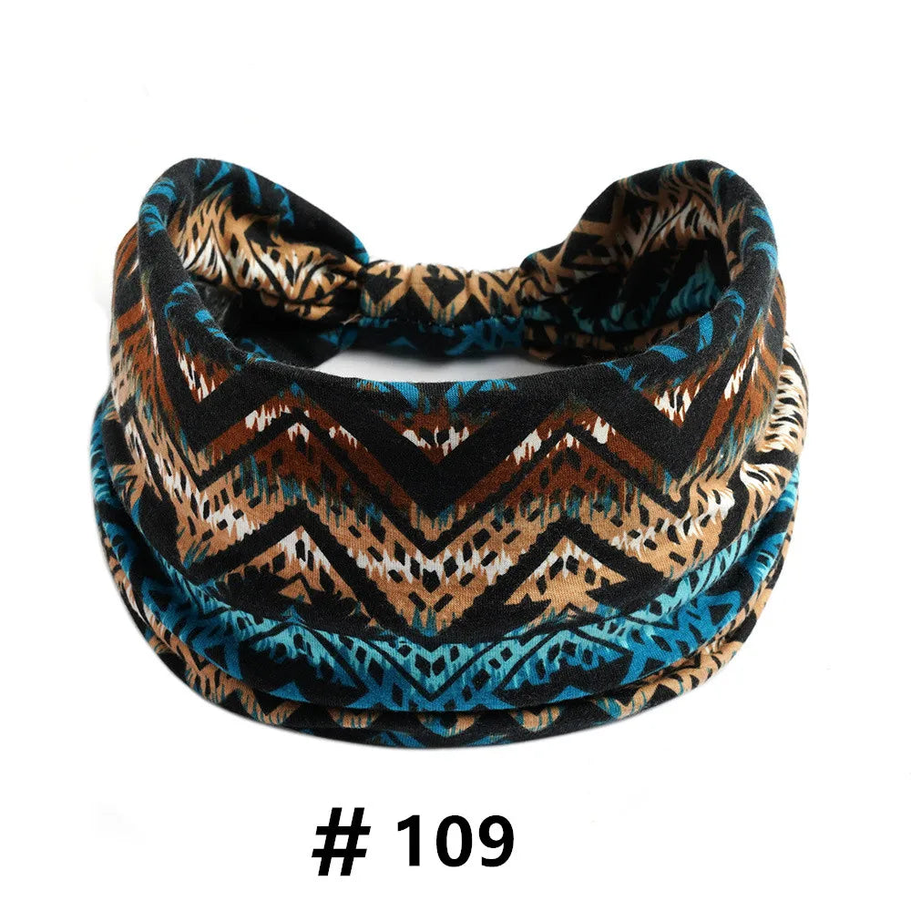 A close-up of a patterned boho cotton turban headband featuring brown, black, and teal geometric designs.