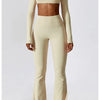 A woman models a beige women's performance tracksuit set consisting of a cropped top and matching full-length pants.