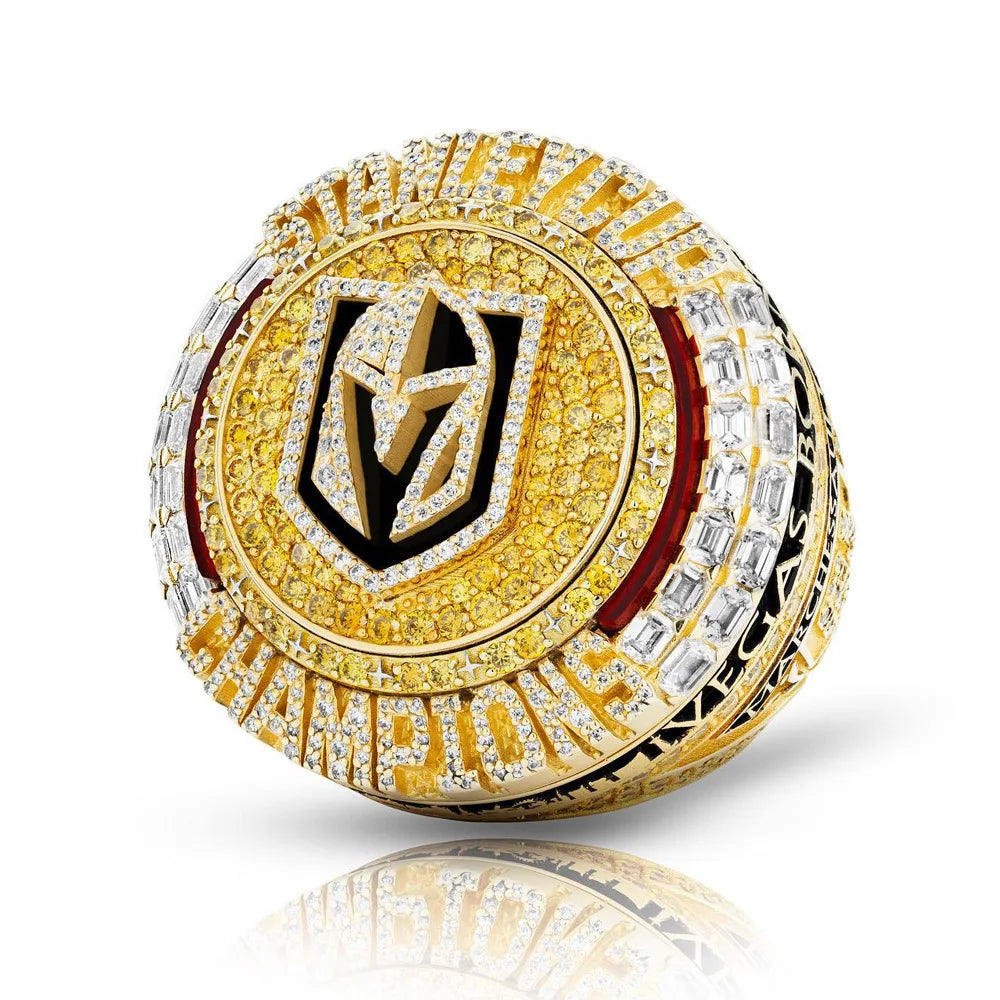 A close-up of a gold and diamond championship ring featuring a black and gold design.