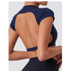 A woman wearing a navy blue women's fitness crop top yoga and gym t-shirt, shown from the back.